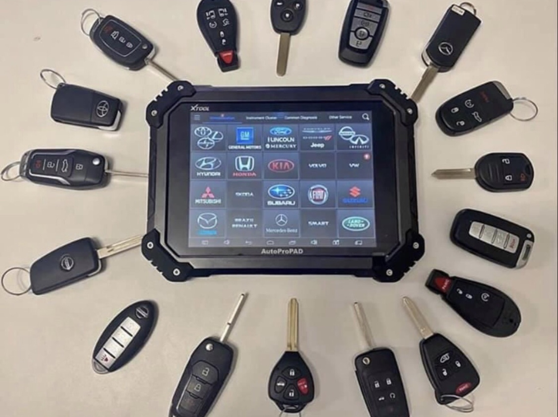 Automotive key programming tablet surrounded by key fobs